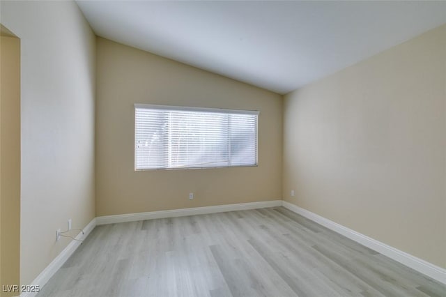 empty room featuring vaulted ceiling and light hardwood / wood-style flooring