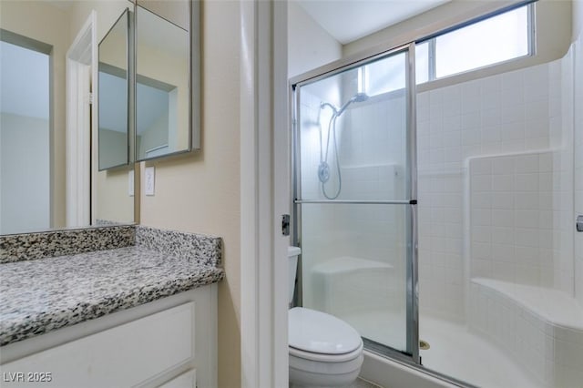 bathroom with toilet, walk in shower, and vanity