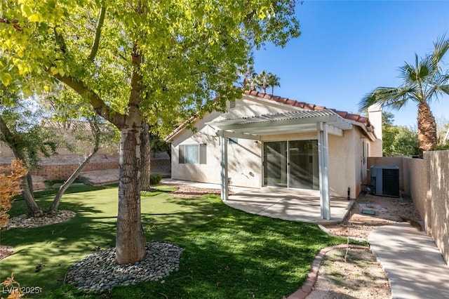 rear view of house with central air condition unit, a pergola, a yard, and a patio area