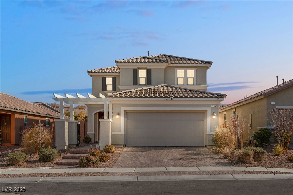 mediterranean / spanish house featuring a pergola and a garage