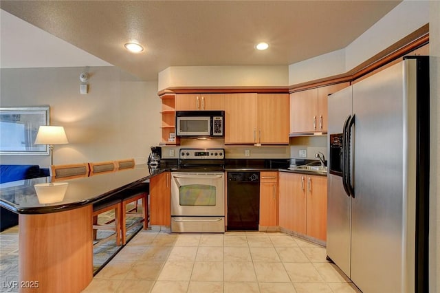 kitchen featuring light tile patterned floors, sink, appliances with stainless steel finishes, and kitchen peninsula