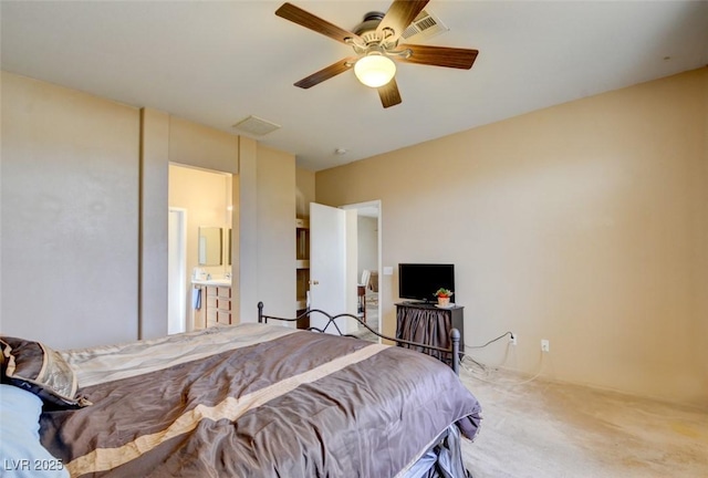 bedroom with ceiling fan, ensuite bathroom, and carpet flooring