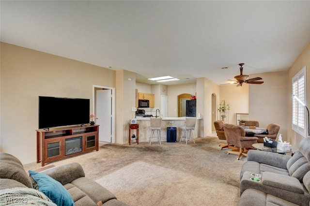 carpeted living room with sink and ceiling fan