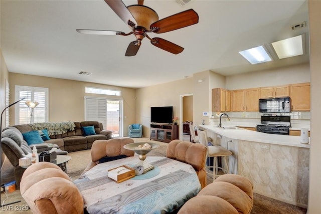 living room with ceiling fan and sink