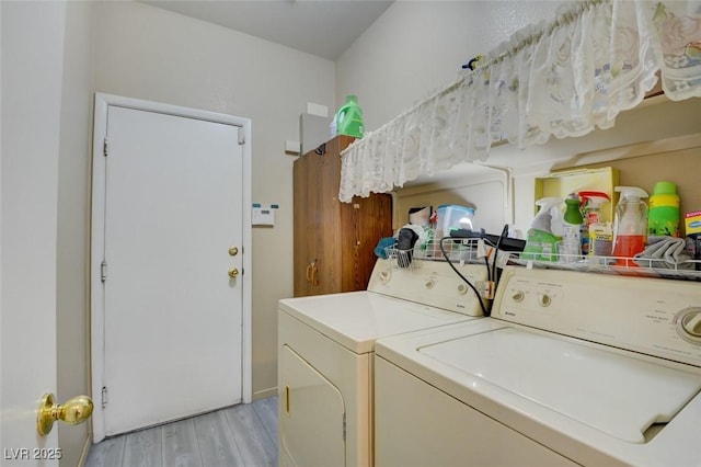 laundry room featuring washer and clothes dryer and light hardwood / wood-style flooring