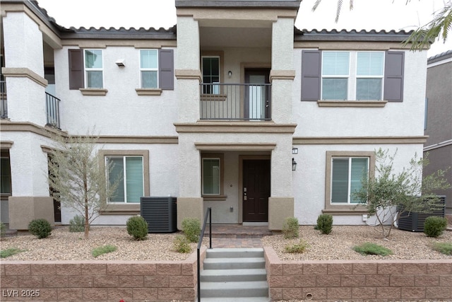 view of front of property featuring a balcony and central air condition unit