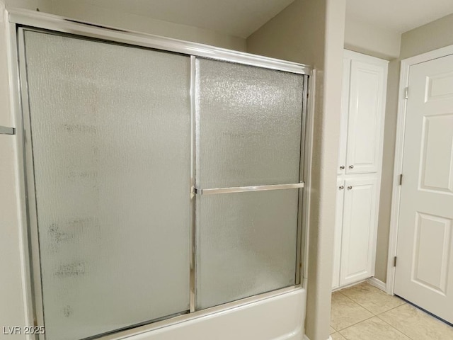 bathroom with combined bath / shower with glass door and tile patterned floors