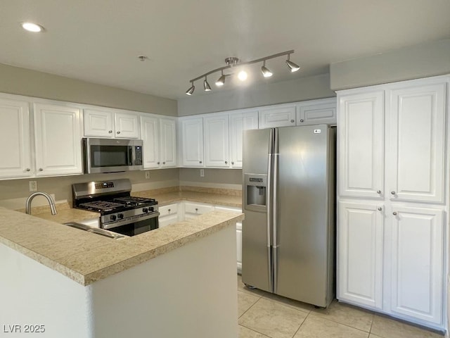 kitchen with white cabinetry, kitchen peninsula, appliances with stainless steel finishes, and light tile patterned flooring