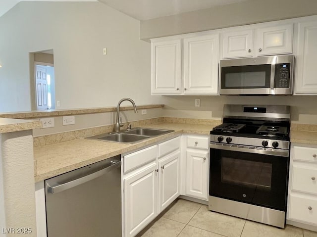 kitchen featuring sink, white cabinetry, light tile patterned floors, and appliances with stainless steel finishes