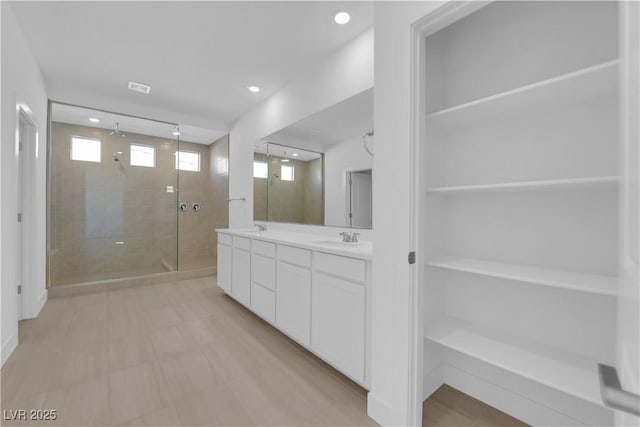 bathroom featuring tiled shower and vanity