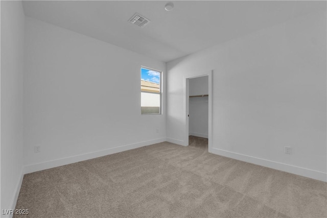 unfurnished bedroom with light colored carpet and a closet