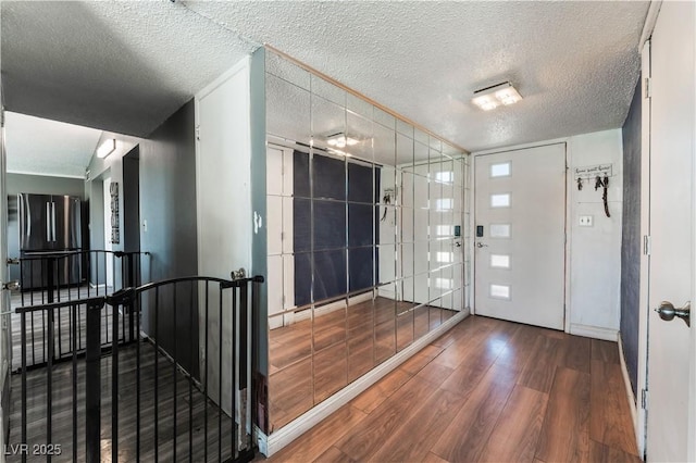 foyer entrance featuring hardwood / wood-style flooring and a textured ceiling