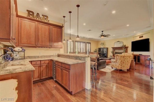 4450 Palisades Canyon Cir, Las Vegas, NV 89129 - kitchen with a sink, light stone countertops, ceiling fan, a kitchen breakfast bar, and wood finished floors