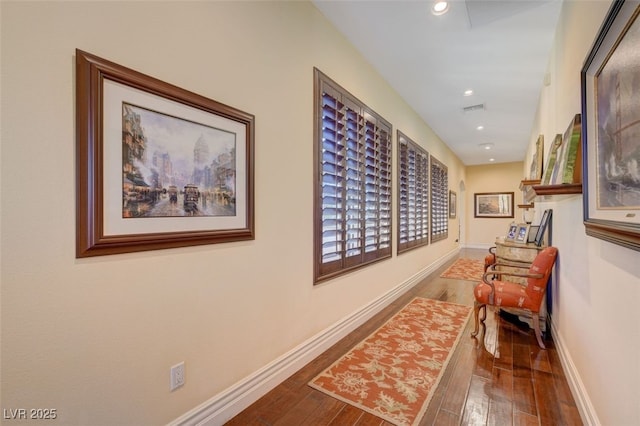 corridor with recessed lighting, visible vents, baseboards, and wood finished floors