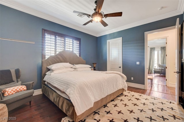 bedroom featuring ceiling fan, ornamental molding, dark wood-type flooring, and multiple windows