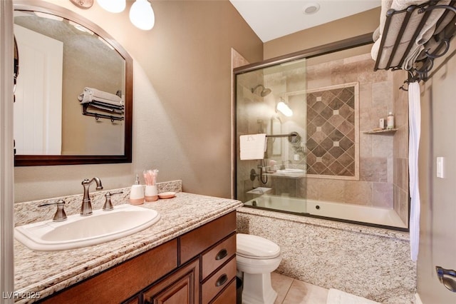 full bathroom featuring tile patterned floors, combined bath / shower with glass door, vanity, and toilet