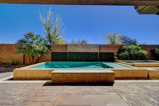 view of swimming pool with a patio area, a fenced backyard, and a jacuzzi