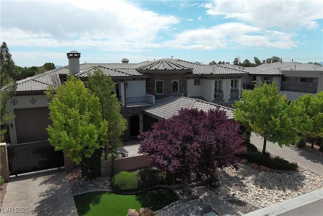 4450 Palisades Canyon Cir, Las Vegas, NV 89129 - view of front of home featuring a tiled roof, a chimney, a garage, stone siding, and stucco siding