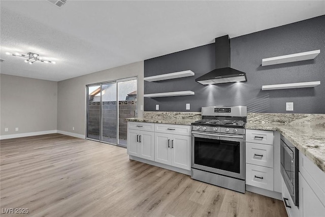 kitchen featuring light stone countertops, white cabinets, wall chimney exhaust hood, stainless steel appliances, and light wood-type flooring