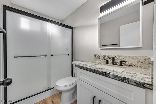 bathroom with vanity, hardwood / wood-style flooring, walk in shower, and toilet