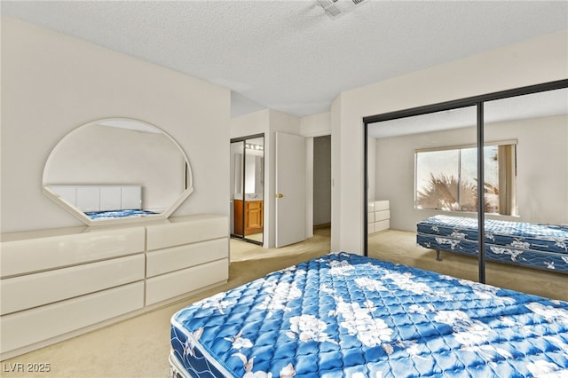 bedroom with a closet, light carpet, and a textured ceiling