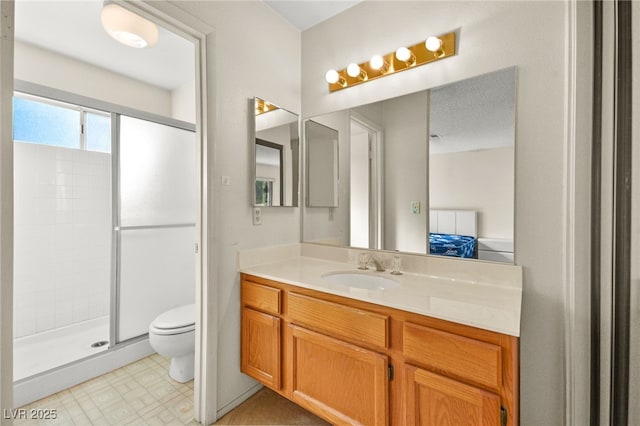 bathroom with an enclosed shower, vanity, and toilet