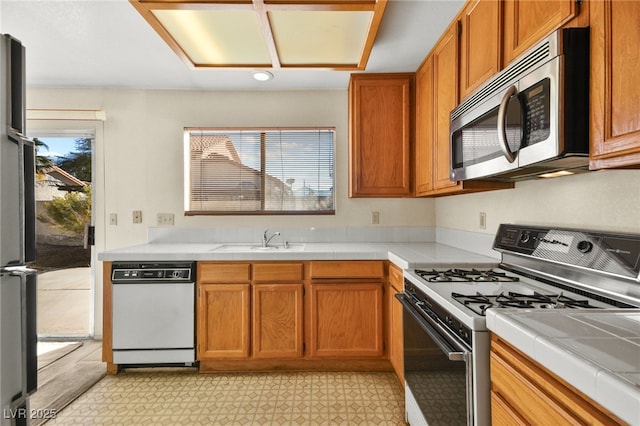 kitchen featuring sink, appliances with stainless steel finishes, and tile countertops