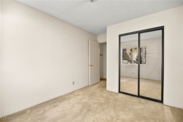 unfurnished bedroom with a closet, light colored carpet, and a textured ceiling