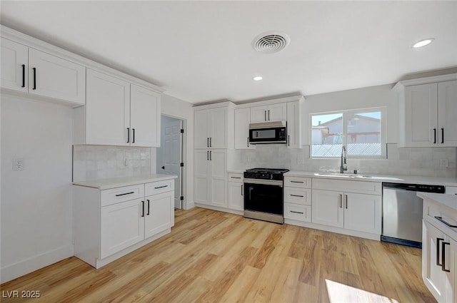 kitchen featuring appliances with stainless steel finishes, sink, and white cabinets