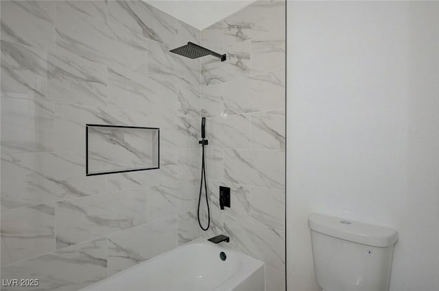 bathroom featuring tiled shower / bath and toilet