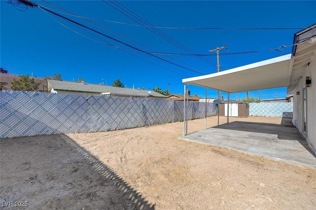 view of yard featuring a patio and a storage shed