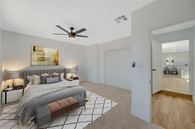 bedroom featuring light carpet, a closet, and ceiling fan