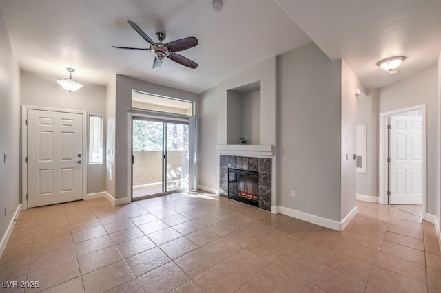 unfurnished living room featuring ceiling fan, a textured ceiling, light tile patterned floors, and a tiled fireplace