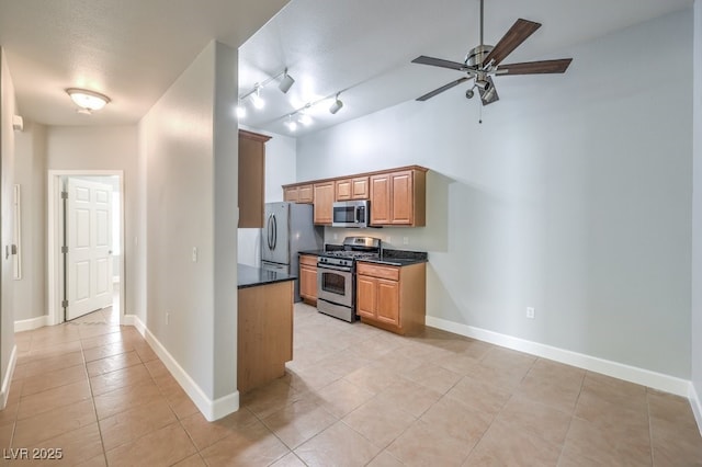 kitchen featuring a textured ceiling, appliances with stainless steel finishes, track lighting, light tile patterned flooring, and ceiling fan