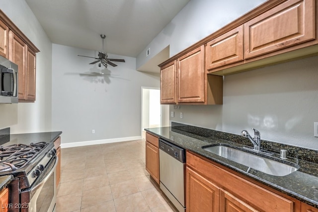 kitchen featuring sink, dark stone counters, ceiling fan, and appliances with stainless steel finishes