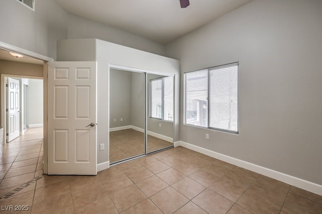 unfurnished bedroom with ceiling fan, a closet, and light tile patterned flooring