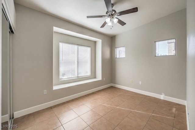 tiled spare room with ceiling fan