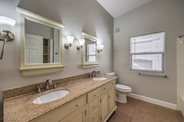 bathroom featuring a healthy amount of sunlight, vaulted ceiling, tile patterned floors, and vanity