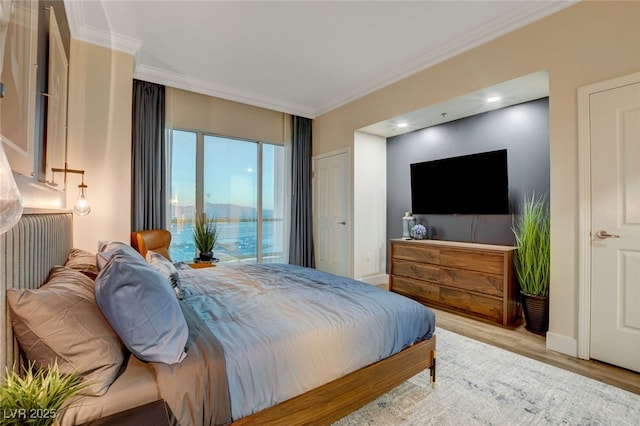 bedroom featuring access to outside, ornamental molding, and light hardwood / wood-style floors