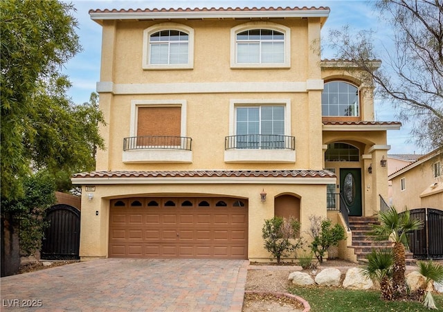 mediterranean / spanish-style home with a garage and a balcony