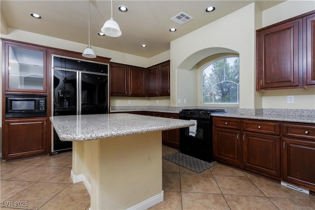 kitchen featuring a center island, light tile patterned floors, pendant lighting, light stone countertops, and black appliances