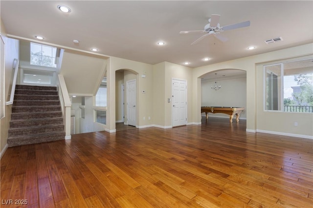 unfurnished living room featuring wood-type flooring, a healthy amount of sunlight, and ceiling fan