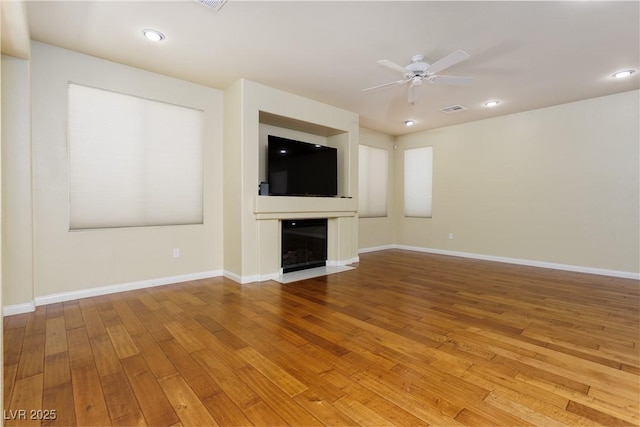 unfurnished living room with wood-type flooring and ceiling fan