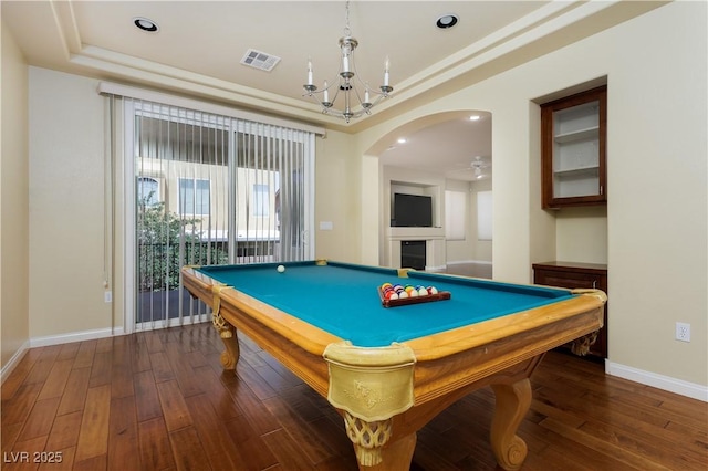 rec room featuring a tray ceiling, dark hardwood / wood-style floors, ceiling fan with notable chandelier, and billiards