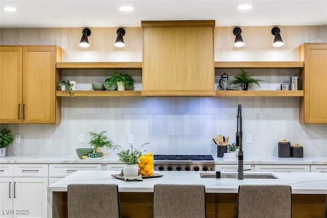 kitchen featuring light stone countertops, backsplash, and white cabinets