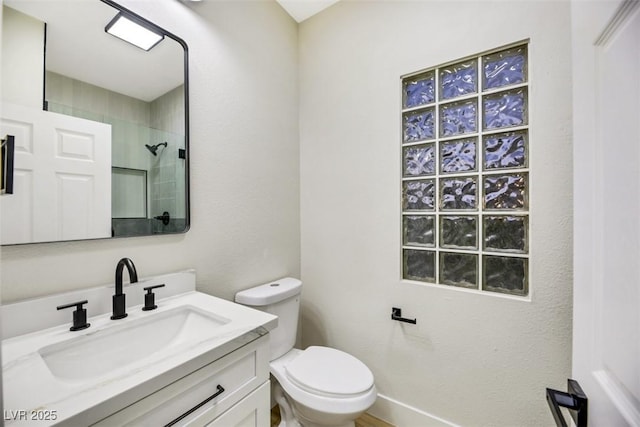 bathroom featuring vanity, toilet, and tiled shower