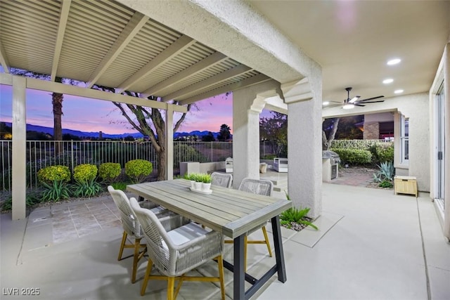 patio terrace at dusk with ceiling fan and grilling area