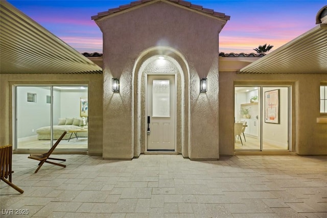 exterior entry at dusk with a patio