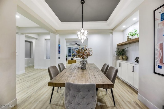 dining room featuring light hardwood / wood-style flooring and a tray ceiling