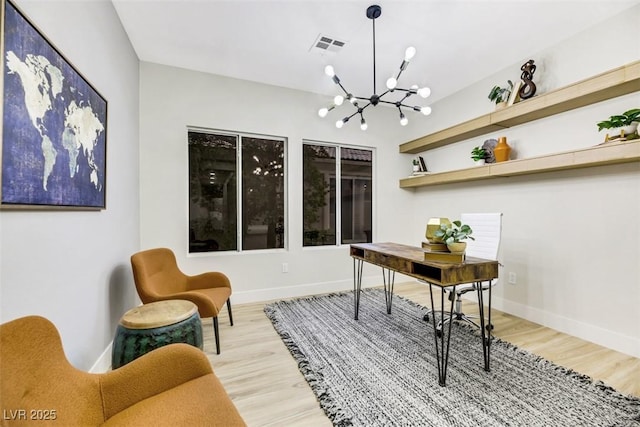 home office featuring a notable chandelier and light hardwood / wood-style flooring